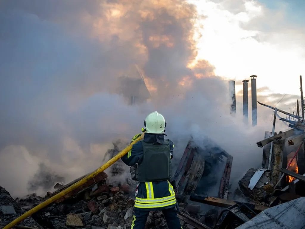 Bombeiros trabalhando para apagar um incêndio causado por um ataque de foguete russo em Lviv, Ucrânia.