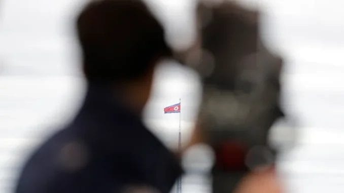 Uma bandeira da Coreia do Norte tremula ao vento, vista da vila da liberdade de Taesungdong, dentro da zona desmilitarizada em Paju, Coreia do Sul, em 24 de abril de 2018 [Lee Jin-man/AP]. Fonte: Al Jazeera